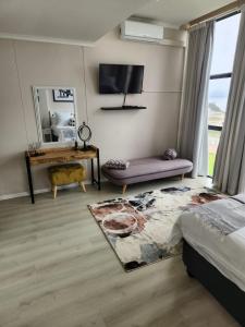 1 dormitorio con cama, mesa y espejo en 13 at Santos, en Mossel Bay