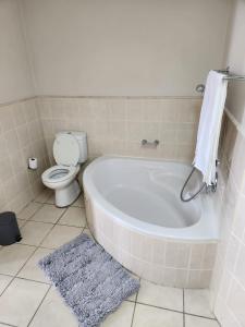 a bathroom with a bath tub and a toilet at 13 at Santos in Mossel Bay