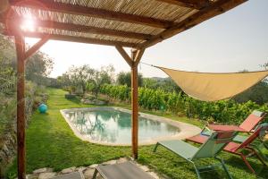 a patio with chairs and an umbrella and a pool at Rietine24 in Gaiole in Chianti