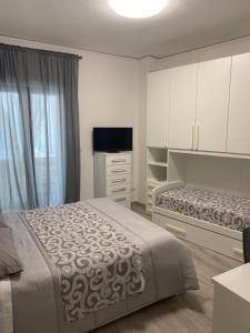a bedroom with two beds and a television in it at Casa Marinella in Vico Equense