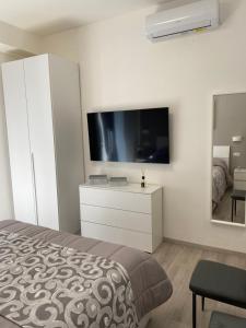 a bedroom with a bed and a tv on a wall at Casa Marinella in Vico Equense