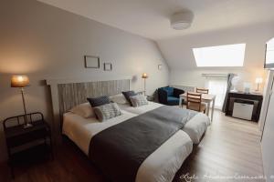 una habitación de hotel con una cama grande y una mesa en Le Relais De La Motte, en Soignies
