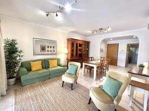 uma sala de estar com um sofá, cadeiras e uma mesa em Olivos del golf - Terrace with pool by HD em Vilamoura
