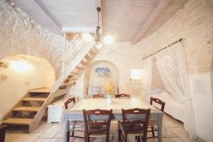 a dining room with a table and a staircase at Trulli Antica Fonte Luxury Suite in Alberobello
