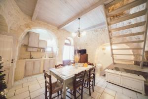 una cucina con tavolo e sedie in una stanza di Trulli Antica Fonte Luxury Suite ad Alberobello