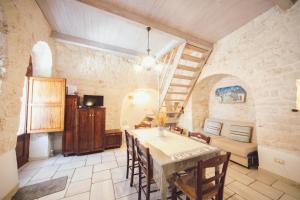 een keuken en eetkamer met een tafel en stoelen bij Trulli Antica Fonte Luxury Suite in Alberobello