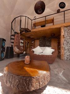 a living room with a tree stump table and a loft at Black Domes in Nevados de Chillan