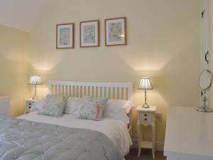 a bedroom with a white bed and two lamps at The Causeway in Eyam