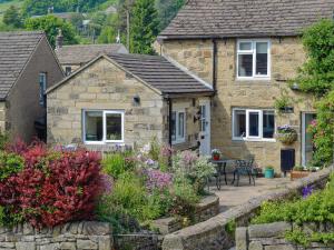 a stone house with a garden in front of it at The Causeway in Eyam
