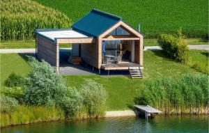 mały domek z niebieskim dachem obok zbiornika wodnego w obiekcie Ferienhaus Am Naturbadesee w mieście Königsdorf
