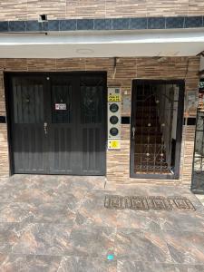 a building with two black doors on a building at Lindo Apartaestudio cerca al centro in Itagüí