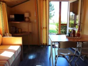 sypialnia z łóżkiem, stołem i oknem w obiekcie Chalets indépendants en camping 2 étoiles avec terrasse – Idéal famille, activités et jeux pour enfants - FR-1-489-405 w mieście Treignat