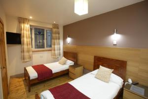 Habitación de hotel con 2 camas y ventana en The Merchant City Inn en Glasgow