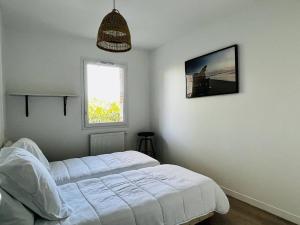 a bedroom with a white bed and a window at Appartement Cambo-les-Bains, 3 pièces, 4 personnes - FR-1-495-115 in Cambo-les-Bains