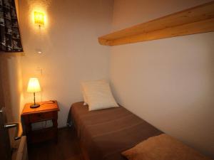 a small room with a bed and a lamp on a table at Appartement Auris, 2 pièces, 3 personnes - FR-1-297-299 in Auris