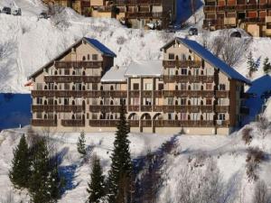 duży hotel na śniegu z pokrytymi śniegiem górami w obiekcie Appartement calme 2 pièces, 300m des pistes avec parking gratuit - Auris en Oisans - FR-1-297-299 w mieście Auris +4 zdjęcia