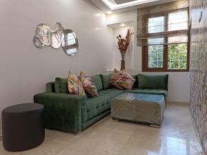 a living room with a green couch and a table at Luxury Family House with Garden View Casablanca in Casablanca