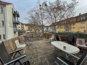 Un patio con sillas y una mesa en un balcón. en Apartments Sülmerstrasse, en Heilbronn