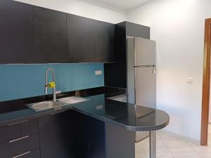 a kitchen with a black counter top and a refrigerator at Luxury Family House with Garden View Casablanca in Casablanca
