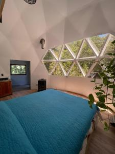 1 dormitorio con 1 cama azul grande frente a una ventana en Black Domes en Nevados de Chillán