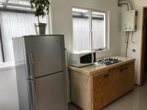 a kitchen with a refrigerator and a microwave at Casa Grande, Alojamiento "BSA" in Cochrane