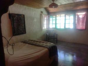 1 dormitorio con 1 cama, 1 silla y 1 ventana en Casa SMA en San Martín de los Andes