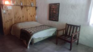 1 dormitorio pequeño con 1 cama y 1 silla en Casa SMA en San Martín de los Andes