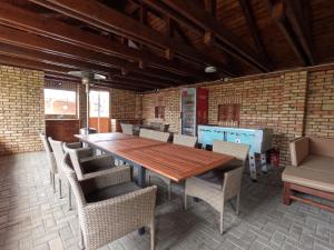 a dining room with a wooden table and chairs at Riviéra Apartmanok in Abádszalók