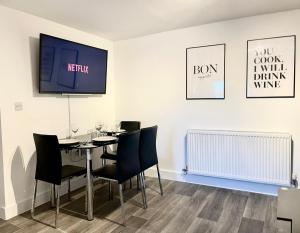 a dining room with a table with chairs and a tv at *Modern & Stylish 2 Double Bedroom-Free Parking!* in Bristol
