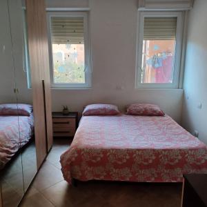 - une chambre avec un lit et 2 fenêtres dans l'établissement Appartamento 9 residance piviere, à Calambrone