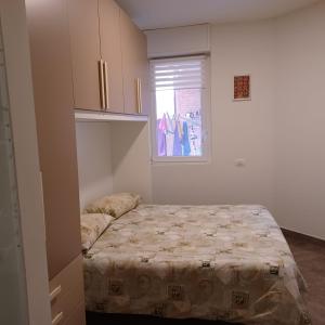 - une petite chambre avec un lit et une fenêtre dans l'établissement Appartamento 9 residance piviere, à Calambrone