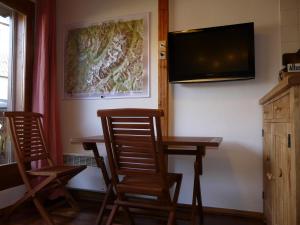 een eetkamer met 2 stoelen en een tafel en een televisie bij Le Rustica, 3 rooms, 3 stars, 6 people in Les Houches