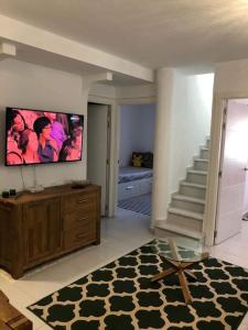 sala de estar con escalera y TV en la pared en Bungalow con Vistas al Mar, en Torrevieja