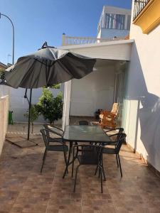 una mesa y sillas con una sombrilla en el patio en Bungalow con Vistas al Mar, en Torrevieja