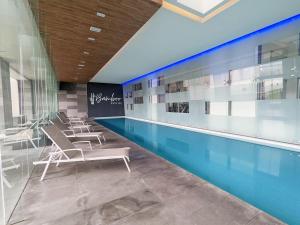 una piscina con sillas junto a una piscina en Luxury Condo Santa Fe Cosmocrat By Bamboo Skylife, en Ciudad de México