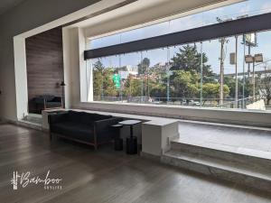 uma sala de estar com um sofá e uma grande janela em Luxury Condo Santa Fe Cosmocrat By Bamboo Skylife em Cidade do México
