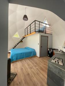 a bedroom with a blue bed and a staircase at Black Domes in Nevados de Chillan