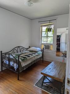 1 dormitorio con cama, mesa y ventana en Historic UVA Apartment - near the corner en Charlottesville
