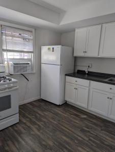 cocina con armarios blancos y nevera blanca en Historic UVA Apartment - near the corner en Charlottesville