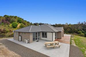 a small house with a picnic table in front of it at Coast View Farm Stay in Opotiki