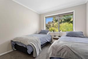 a bedroom with two beds and a window at Coast View Farm Stay in Opotiki