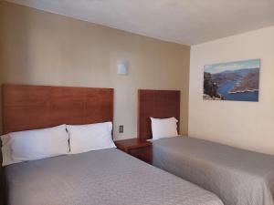 una habitación de hotel con 2 camas y un lago en Posada del Ángel, en Pachuca de Soto