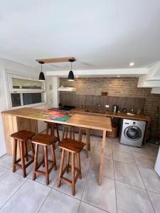 cocina con mesa de madera y taburetes en La Pampita en Villa Arelaquen Casa M14 en San Carlos de Bariloche