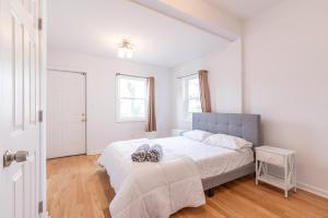 um quarto com uma cama grande num quarto branco em TRANQUIL TOWN HOUSE IN NEW JERSEY - JUST 25 MINUTES To TIME SQUARE! em Jersey City