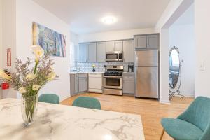 a kitchen with a table with a vase of flowers on it at TRANQUIL TOWN HOUSE IN NEW JERSEY - JUST 25 MINUTES To TIME SQUARE! in Jersey City