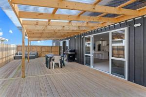a wooden deck with a wooden pergola at Waiotahe Executive Getaway in Opotiki