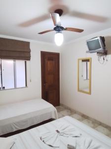 1 dormitorio con 2 camas y ventilador de techo en Clube Praiano, en Cabo Frío