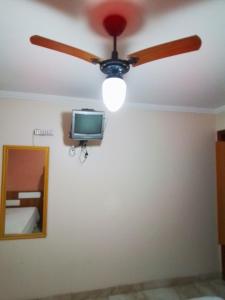 ventilador de techo y TV en la pared en Clube Praiano, en Cabo Frío