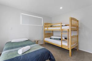 a bedroom with a bunk bed and a bunk ladder at Okioki Te Kaha Holiday Home in Te Kaha