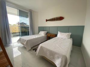 a room with two beds and a large window at Apto de alto padrão 100 m da Praia de Costazul - WIFI 200MB - TV Smart - 2 Quartos - Garagem - Cozinha equipada - Churrasqueira in Rio das Ostras
